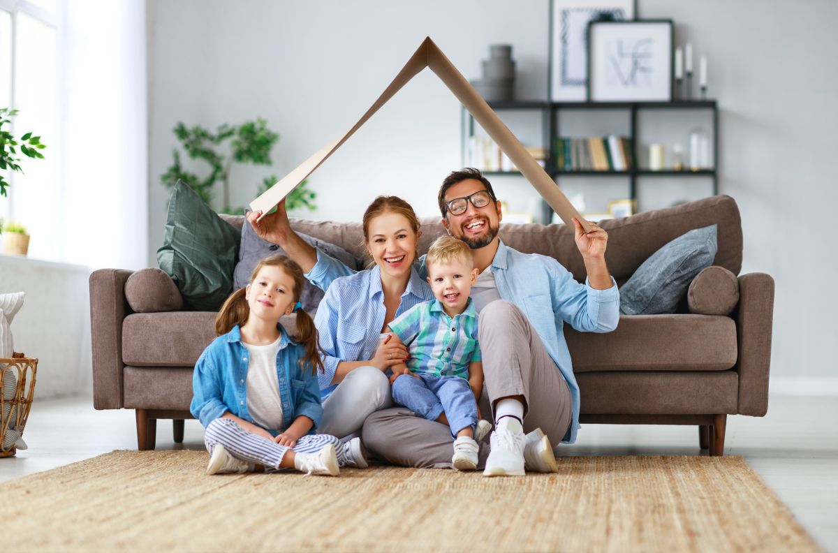 happy family mother father and kids with roof at home