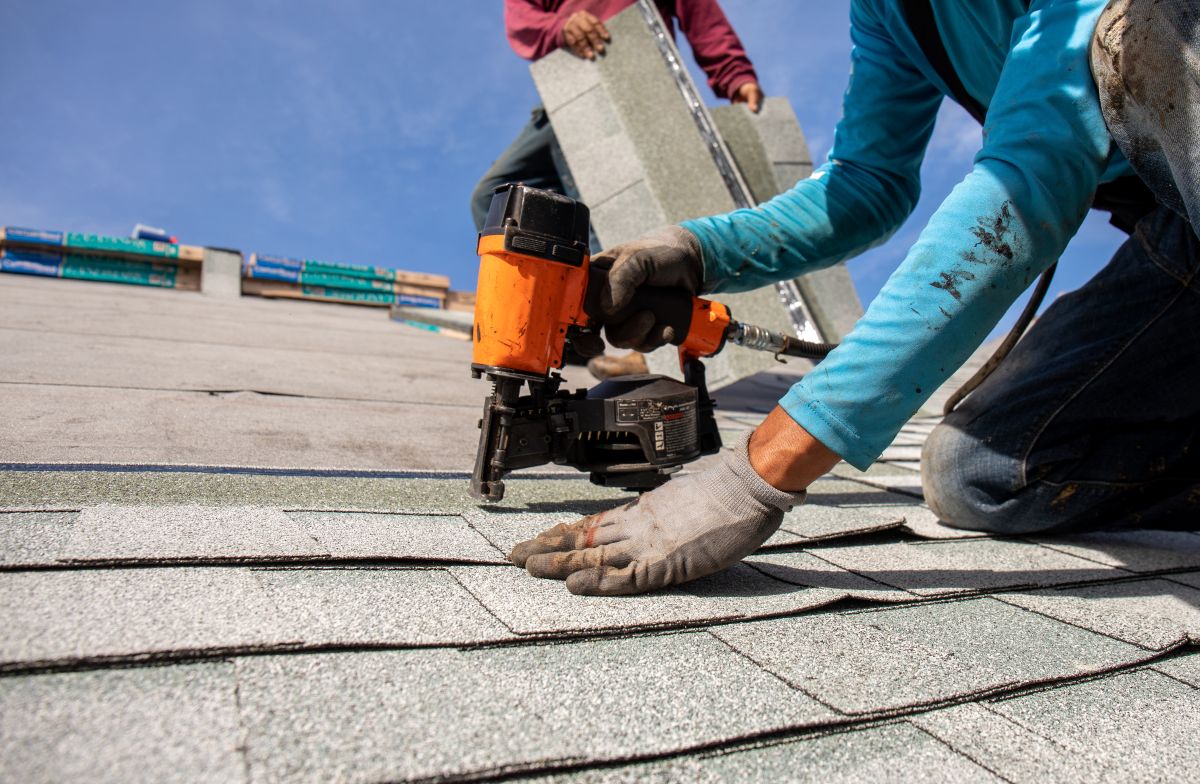 Roofer installing shingles on a clear Minneapolis afternoon
